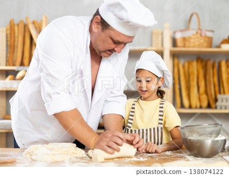 Bakers dad teaches his daughter niece to knead dough Bakers dad teaches his daughter niece to knead dough 138074122