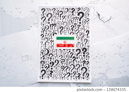 Iran flag sticker placed on paper covered question marks over blurred geographic maps. energy security, oil price surge, Strait of Hormuz closure, global supply disruption, fuel rationing 138074335