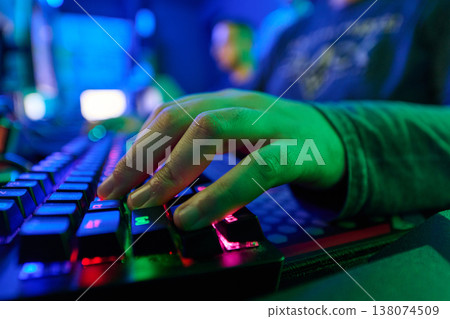 Gamer Hands Typing On RGB Mechanical Keyboard In Neon-Lit Gaming Setup Gamer Hands Typing On RGB Mechanical Keyboard In Neon-Lit Gaming Setup 138074509
