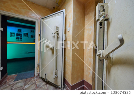 Open Heavy Vault Door Leading to Dimly Lit Corridor in Industrial Bunker Interior 138074525