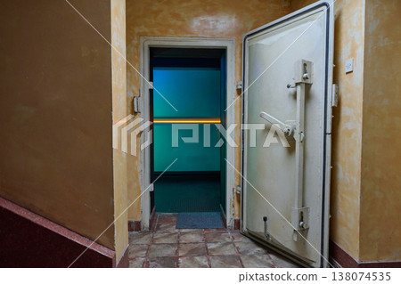 Open Vault Door in Dimly Lit Interior Corridor With Teal Light and Heavy Metal Hatch Open Vault Door in Dimly Lit Interior Corridor With Teal Light and Heavy Metal Hatch 138074535
