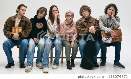 Mixed group of people sitting and waiting showing boredom and fatigue in studio Mixed group of people sitting and waiting showing boredom and fatigue in studio 138074771