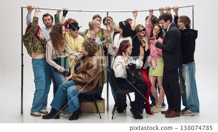 Diverse group of people standing very close holding rail in tight subway setup. 138074785