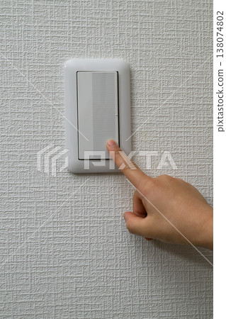 A hand pressing a wall switch and vertical copy space. 138074802