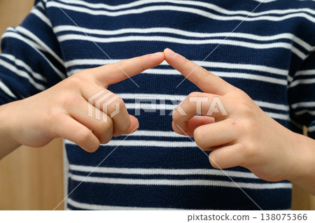 孩子的雙手,手指相觸,還有一件條紋襯衫。 孩子的雙手,手指相觸,還有一件條紋襯衫。 138075366