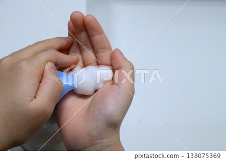 孩子的手拿起泡沫豐富的肥皂,以及周圍的空間。 孩子的手拿起泡沫豐富的肥皂,以及周圍的空間。 138075369