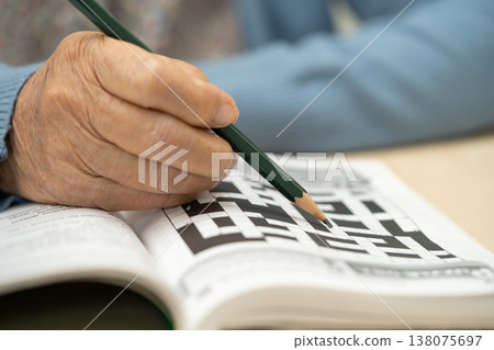 Asian elderly woman playing puzzle game. Asian elderly woman playing puzzle game. 138075697