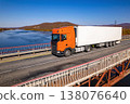 Orange truck on a bridge over the river 138076640