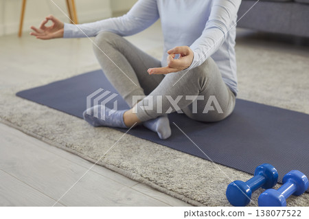 Senior woman meditating on sports mat, practicing yoga and doing breathing exercises at home. 138077522