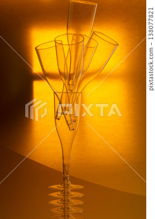 Still life with transparent empty glasses on a yellow-orange background 138077821