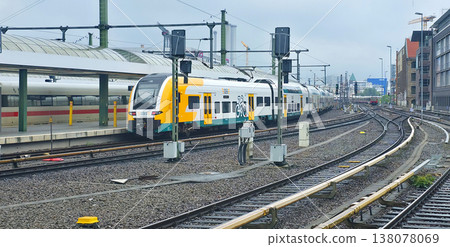 Berlin, Germany - July 21, 2025: Modern passenger train at railway station with tracks and signals visible Berlin, Germany - July 21, 2025: Modern passenger train at railway station with tracks and signals visible 138078069