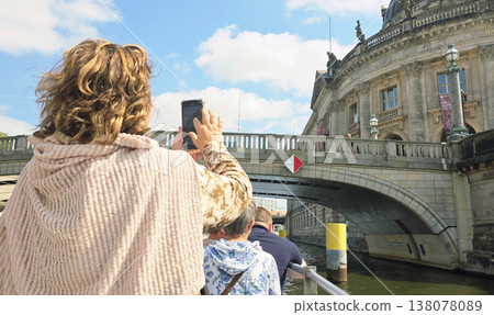 Berlin, Germany - August 16, 2025: Tourist capturing photo of historic building from boat on river Berlin, Germany - August 16, 2025: Tourist capturing photo of historic building from boat on river 138078089