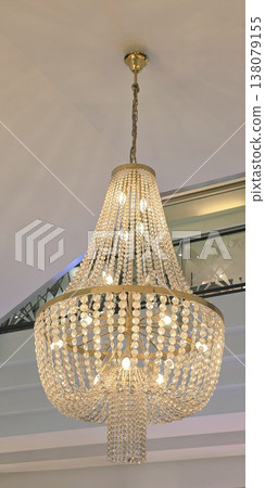 Elegant crystal chandelier hanging from ceiling in modern interior space 138079155