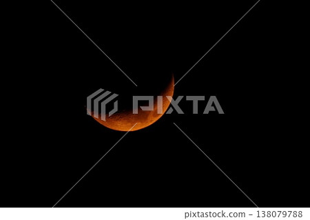 A red crescent moon, photographed with a 1200mm super-telephoto lens, against a fantastical night sky. 138079788