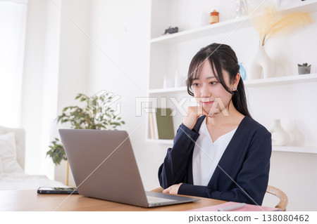 一位二十多歲的女性神情憂慮地看著電腦。 138080462