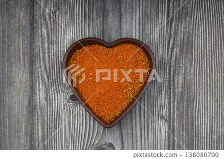 Cajun seasoning in a heart shaped bowl on a wooden background 138080700