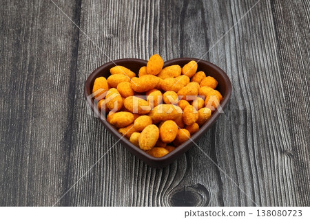 Crunchy Coated Peanuts in a Heart Shaped Bowl Isolated on White Background Crunchy Coated Peanuts in a Heart Shaped Bowl Isolated on White Background 138080723