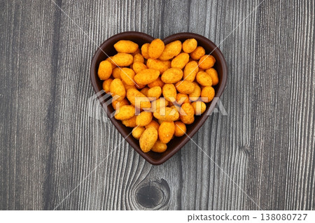 Crunchy Coated Peanuts in a Heart Shaped Bowl Isolated on White Background Crunchy Coated Peanuts in a Heart Shaped Bowl Isolated on White Background 138080727