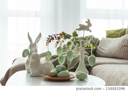 Cozy Easter Living Room Decor with Bunny Figurines and Hanging Eggs on White Table Cozy Easter Living Room Decor with Bunny Figurines and Hanging Eggs on White Table 138081096