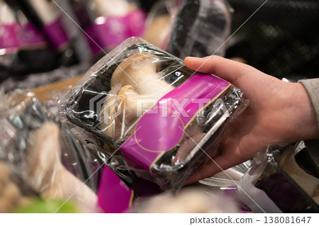 A shopper picks up king oyster mushrooms at the supermarket. 138081647