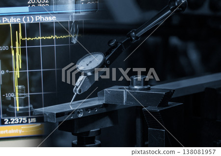 Abstract industrial scene of a dial gauge setup for workpiece leveling integrated with a digital data graph display in a blue-toned tech environment. Abstract industrial scene of a dial gauge setup for workpiece leveling integrated with a digital data graph display in a blue-toned tech environment. 138081957