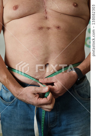 close-up of a fat man measuring his belly close-up of a fat man measuring his belly 138082303