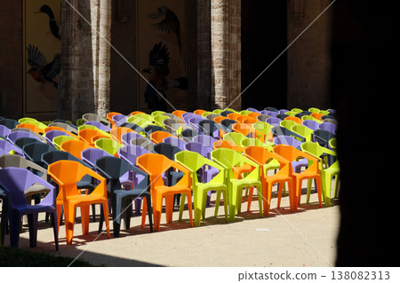 rows of colorful plastic chairs and an open-air auditorium 138082313