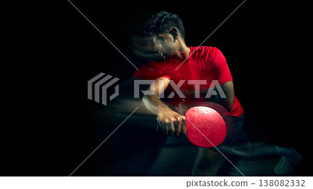 Table tennis player hitting ball with motion blur in dark studio with copy space. 138082332