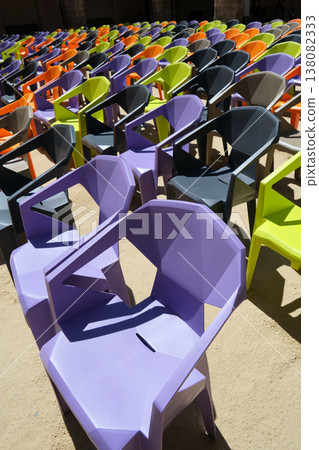 rows of colorful plastic chairs and an open-air auditorium 138082333