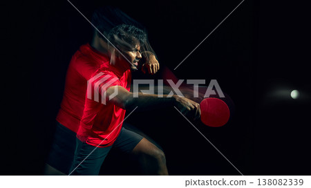 Table tennis player reacting to fast ball with motion blur in dark studio. Table tennis player reacting to fast ball with motion blur in dark studio. 138082339