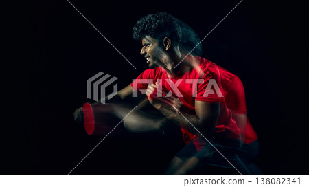 Table tennis player planning shot strategy during gameplay moment in dark studio. Table tennis player planning shot strategy during gameplay moment in dark studio. 138082341