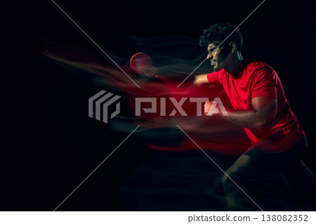 Table tennis player with motion blur effect showing speed and dynamic movement in dark studio Table tennis player with motion blur effect showing speed and dynamic movement in dark studio 138082352