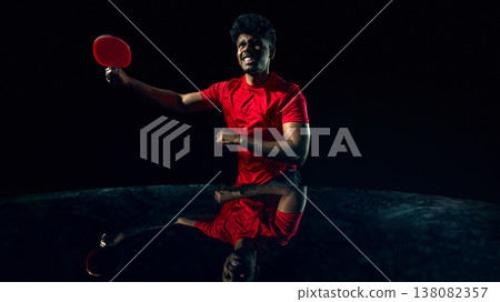 Table tennis player reacting to fast ball in dark studio with reflection surface. Table tennis player reacting to fast ball in dark studio with reflection surface. 138082357