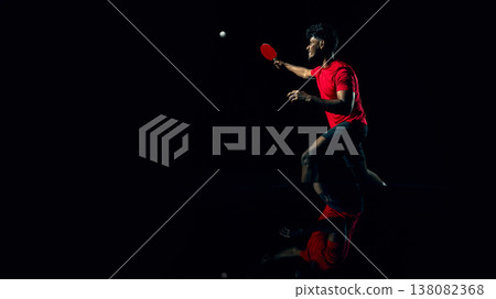 Professional table tennis athlete preparing serve in minimal dark arena style. Professional table tennis athlete preparing serve in minimal dark arena style. 138082368