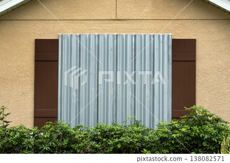 Steel storm shutters for hurricane protection of house windows. Protective measures before natural disaster in Florida Steel storm shutters for hurricane protection of house windows. Protective measures before natural disaster in Florida 138082571