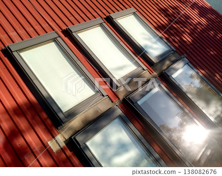 Red tiled house roof with attic windows. Roofing construction, window installation, modern architecture concept. 138082676