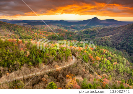 Peaceful mountain road in North Carolina during peak fall season at sunset. Appalachian landscape filled with vivid autumn colors Peaceful mountain road in North Carolina during peak fall season at sunset. Appalachian landscape filled with vivid autumn colors 138082741