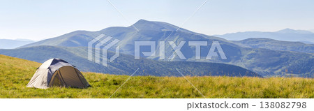 Mountain panorama with tourist tent. Sunrise or sunset in mountains. Hiking concept. 138082798