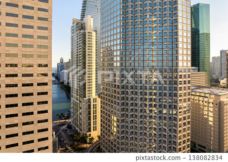 Miami, coastal city in Florida at sunset. Waterfront skyscraper buildings in downtown district of USA urban area. American megapolis with business financial district Miami, coastal city in Florida at sunset. Waterfront skyscraper buildings in downtown district of USA urban area. American megapolis with business financial district 138082834