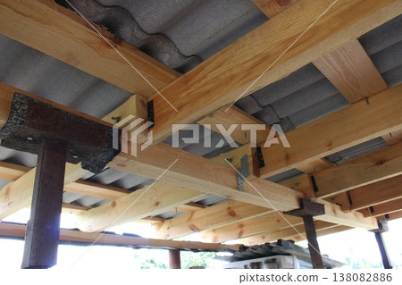 Wooden roof frame construction with metal brackets and corrugated sheets, beams connected with steel angles Wooden roof frame construction with metal brackets and corrugated sheets, beams connected with steel angles 138082886