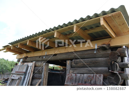Wooden beam framework with galvanized metal connectors and corrugated roof covering, residential construction detail Wooden beam framework with galvanized metal connectors and corrugated roof covering, residential construction detail 138082887