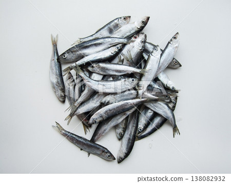 Frozen seafood anchovies and herring fish sprat on brick of ice and snow, shoaling fish on ice. 138082932