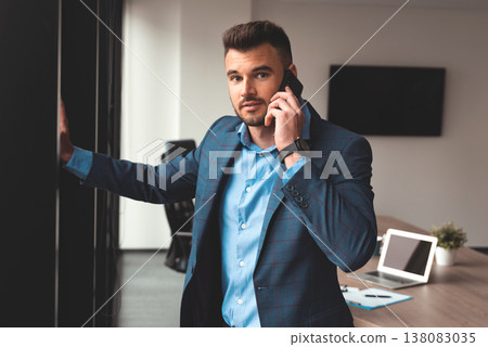 Portrait of a businessman in the office with phone Portrait of a businessman in the office with phone 138083035