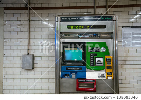 A close view of a MetroCard payment machine inside a Manhattan subway station. The digital screen and payment slots highlight public transportation fare technology in NYC. A close view of a MetroCard payment machine inside a Manhattan subway station. The digital screen and payment slots highlight public transportation fare technology in NYC. 138083340