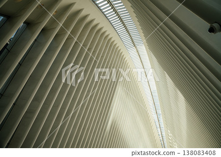 A close perspective highlights the white architectural ribs and glass skylight inside the Oculus in Manhattan. The modern structure emphasizes repetition, symmetry, and innovative design. 138083408