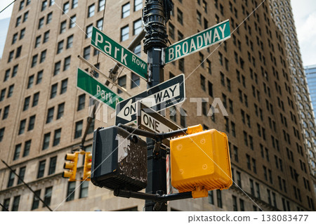 Close up of Broadway and Park Row street signs at a Manhattan intersection in New York City. Skyscrapers and office buildings form the background of the downtown financial district. Close up of Broadway and Park Row street signs at a Manhattan intersection in New York City. Skyscrapers and office buildings form the background of the downtown financial district. 138083477