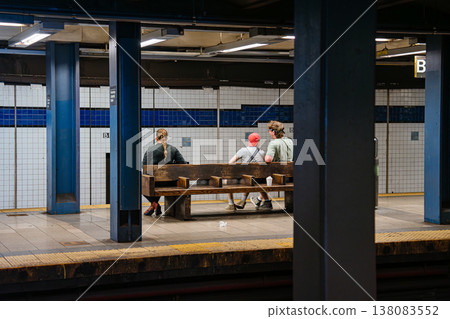 Passengers waiting on wooden bench at Broadway Lafayette Street subway station in Manhattan. Underground New York City metro platform scene showing urban commute, tiled walls, and transit Passengers waiting on wooden bench at Broadway Lafayette Street subway station in Manhattan. Underground New York City metro platform scene showing urban commute, tiled walls, and transit 138083552