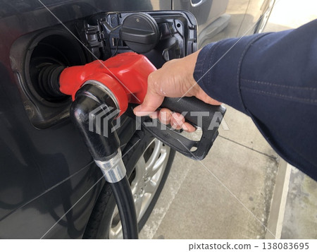 A man filling up a gas station A man filling up a gas station 138083695