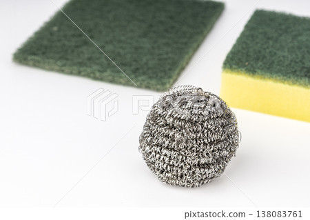 Stainless Steel Wire Wool Scrubber Ball Alongside Green Abrasive Scouring Pads and a Yellow Kitchen Dishwashing Sponge Isolated on Clean White Background for Household Cleaning Concept Stainless Steel Wire Wool Scrubber Ball Alongside Green Abrasive Scouring Pads and a Yellow Kitchen Dishwashing Sponge Isolated on Clean White Background for Household Cleaning Concept 138083761