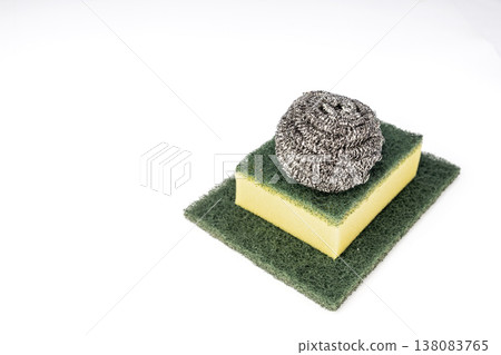 Stainless Steel Wool Scrubber Ball Resting on Yellow Kitchen Sponge and Green Abrasive Scrub Pad Isolated on Clean White Background for Dishwashing 138083765